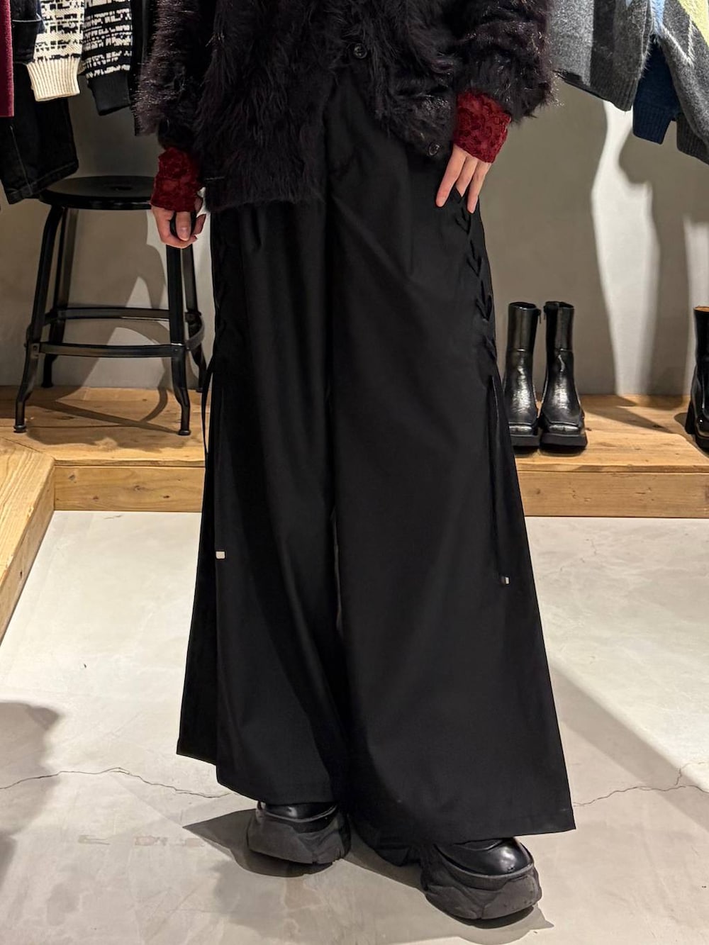 ブラック系のカーディガン/ボレロ、ブラック系のその他パンツ、レッド系のTシャツ/カットソーを着用したレディースの秋コーディネートの5枚目の写真