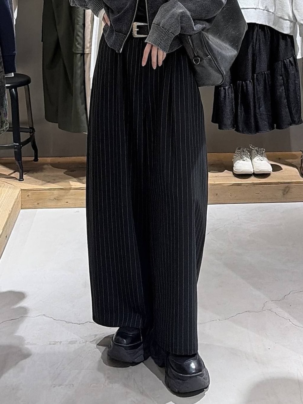 ブラック系のボストンバッグ、ブラック系のスラックス、グレー系のパーカーを着用したレディースの冬コーディネートの5枚目の写真