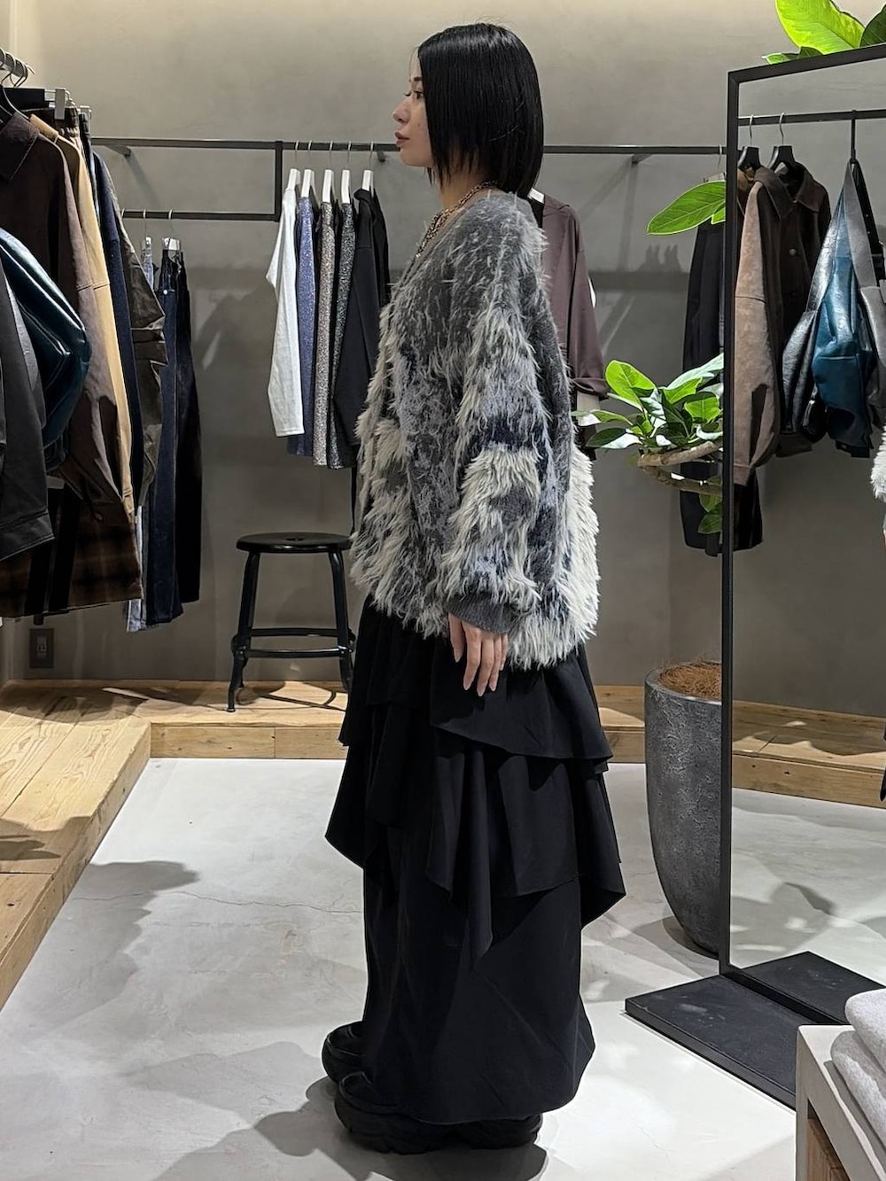 ブラック系のブーツ、ブラック系のキャミソール、ブラック系のスカートを着用したレディースの秋コーディネートの2枚目の写真