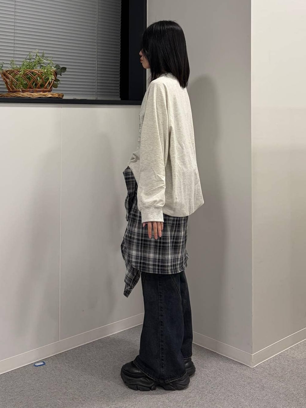 ブラック系のブーツ、ブルー系のデニムパンツ、ベージュ系のTシャツ/カットソーを着用したレディースの春コーディネートの2枚目の写真