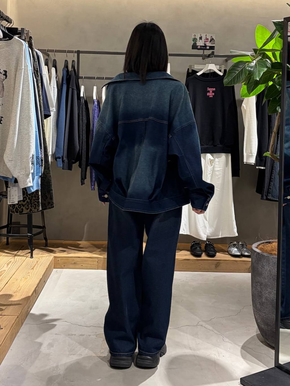 ブラック系のブーツ、ホワイト系のTシャツ/カットソー、ブルー系のスラックスを着用したレディースの春コーディネートの3枚目の写真