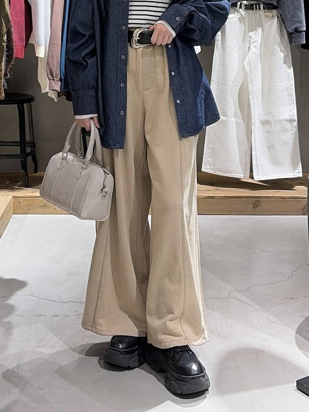 ブラック系のブーツ、ホワイト系のボストンバッグ、ブラウン系のスウェットパンツを着用したレディースの冬コーディネートの5枚目の写真