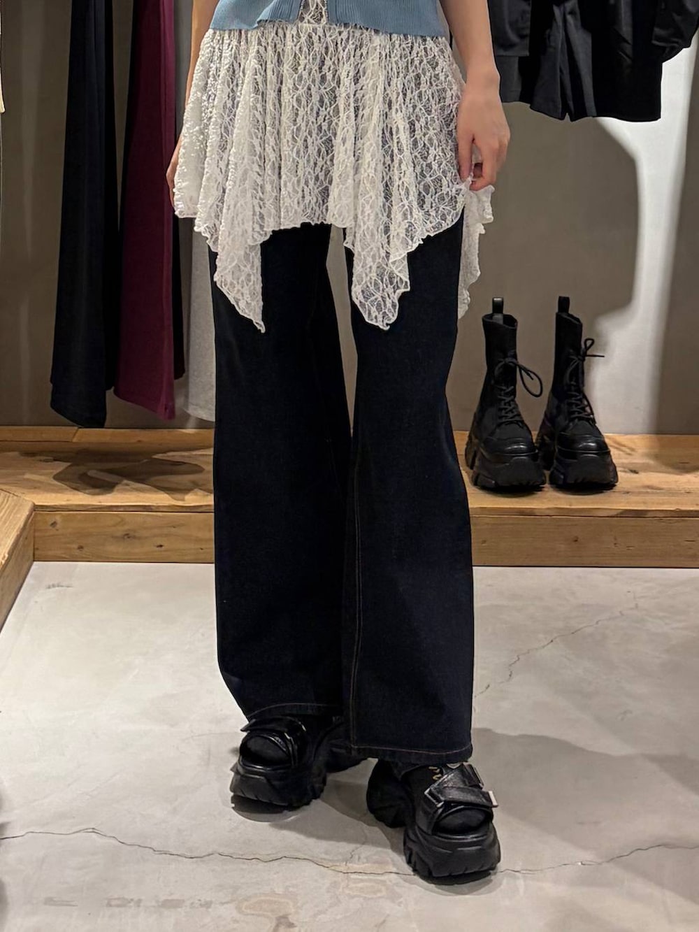ブルー系のデニムパンツ、ブラック系のサンダル、ホワイト系のチュニックを着用したレディースの春コーディネートの5枚目の写真