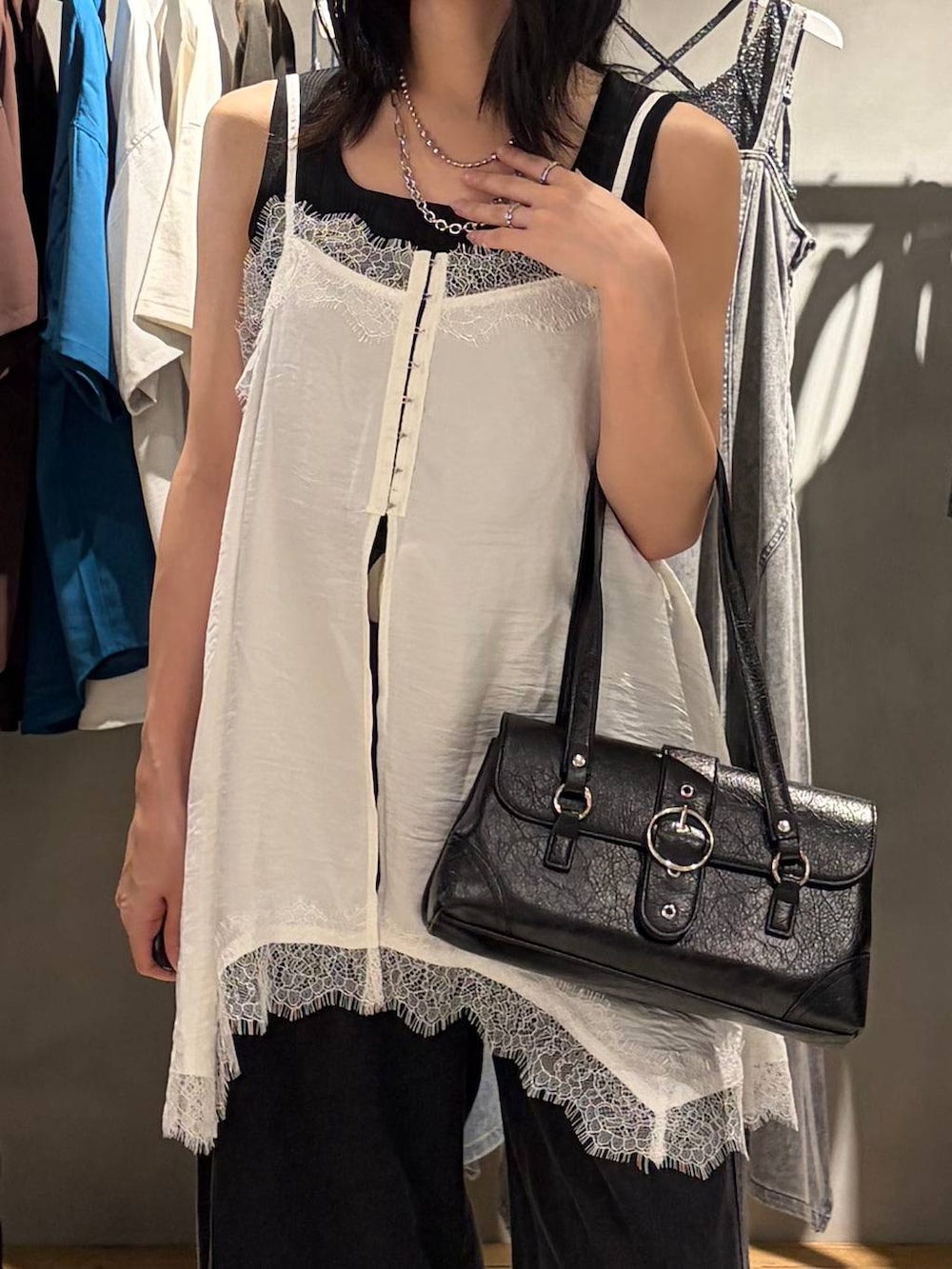 ブラック系のデニムパンツ、ブラック系のスニーカー、ブラック系のタンクトップを着用したレディースの夏コーディネートの4枚目の写真