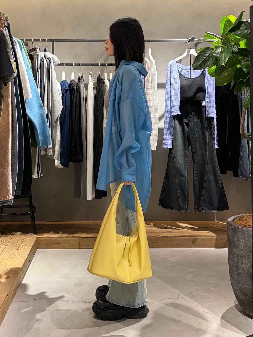 ブラック系のブーツ、グレー系のキャミソール、ブルー系のデニムパンツを着用したレディースの春コーディネートの2枚目の写真