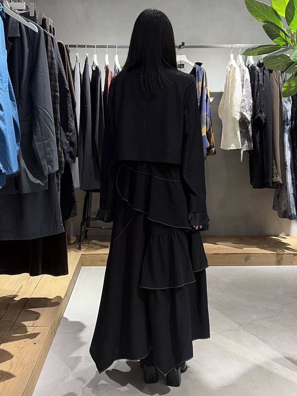 ブラック系のスカート、ブラック系のテーラードジャケット、ブラック系のサンダルを着用したレディースの夏コーディネートの3枚目の写真