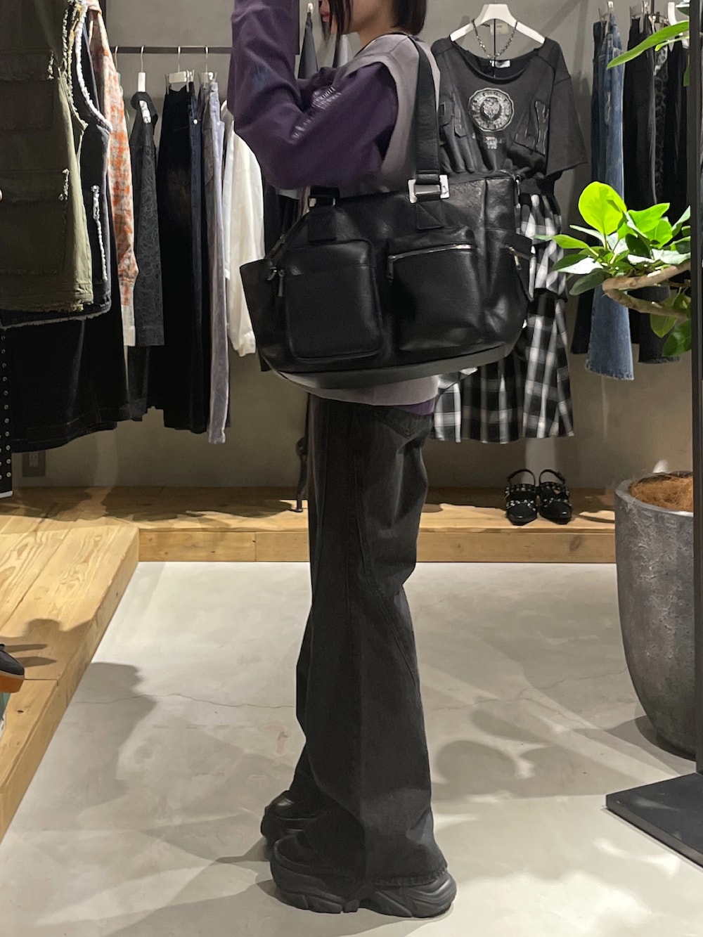 グレー系のベスト、パープル系のTシャツ/カットソー、ブラック系のボストンバッグを着用したレディースの秋コーディネートの2枚目の写真