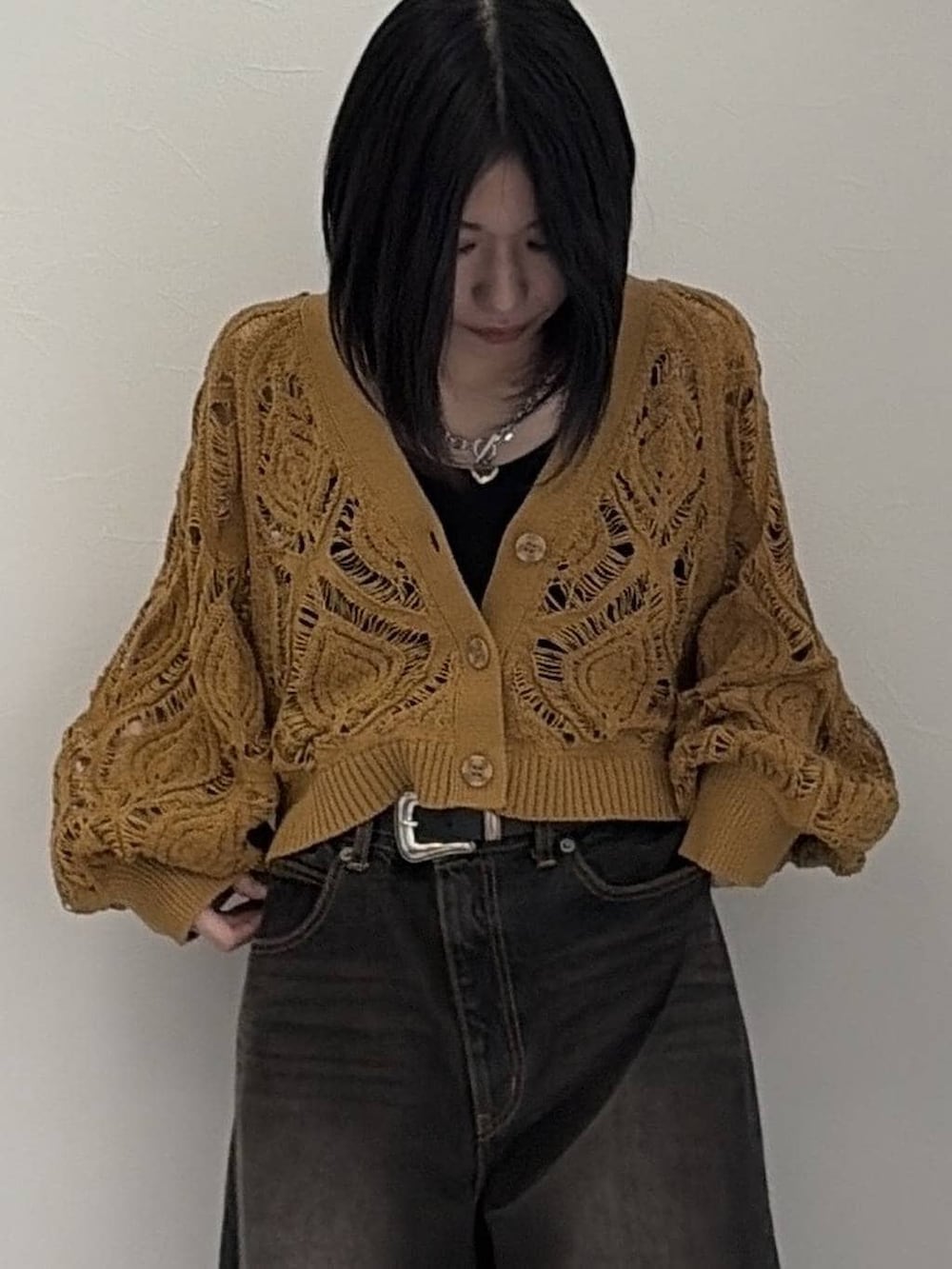 イエロー系のカーディガン/ボレロ、ブラック系のデニムパンツ、シルバー系のネックレスを着用したレディースの冬コーディネートの4枚目の写真