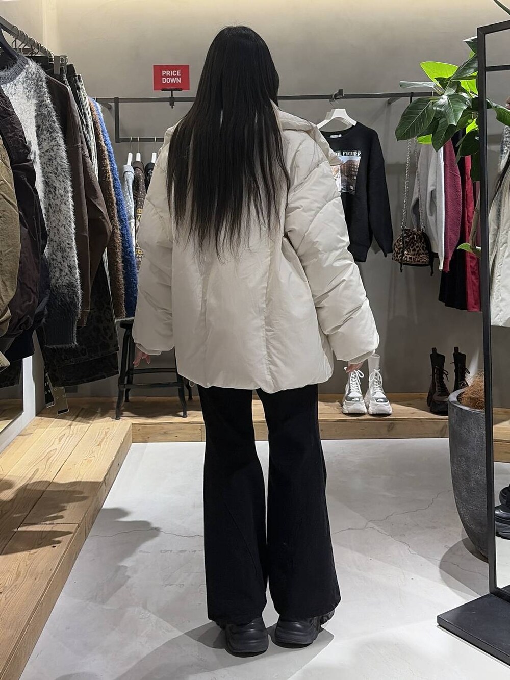 ブラック系のブーツ、ブラック系のデニムパンツ、ホワイト系のブルゾンを着用したレディースの冬コーディネートの3枚目の写真