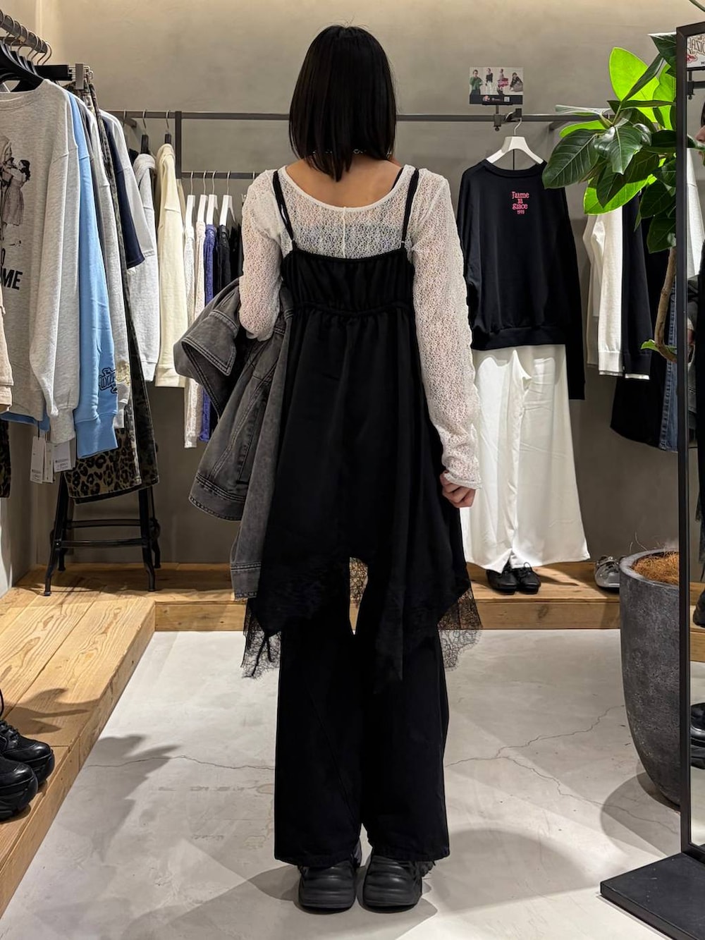 ブラック系のブーツ、ブラック系のデニムパンツ、ホワイト系のボストンバッグを着用したレディースの冬コーディネートの3枚目の写真