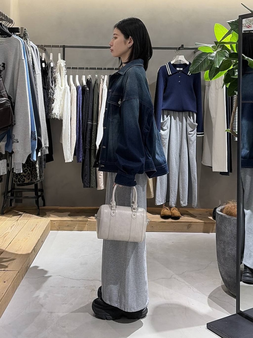 ブラック系のブーツ、ホワイト系のボストンバッグ、グレー系のスウェットを着用したレディースの冬コーディネートの2枚目の写真