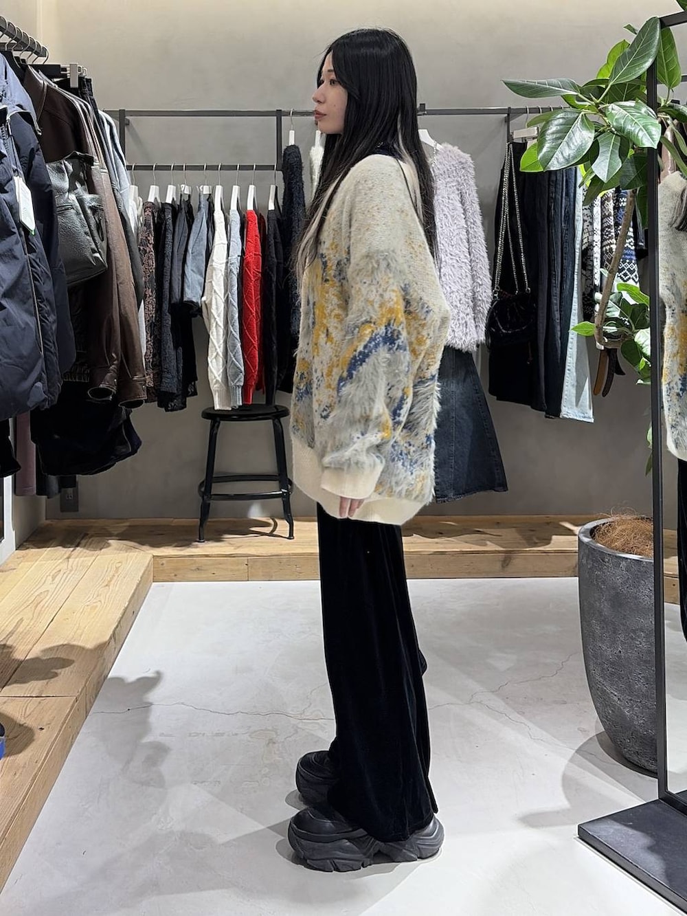 ブラック系のブーツ、ホワイト系のカーディガン/ボレロ、ブラック系のその他パンツを着用したレディースの冬コーディネートの2枚目の写真