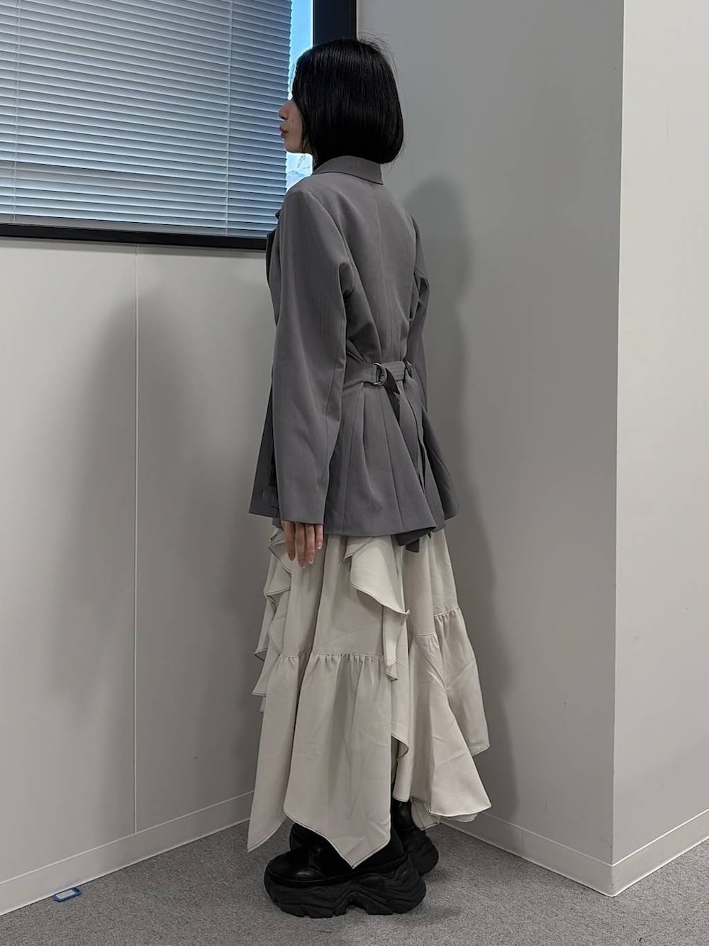 ブラック系のブーツ、ブラック系のニット/セーター、グレー系のテーラードジャケットを着用したレディースの冬コーディネートの2枚目の写真