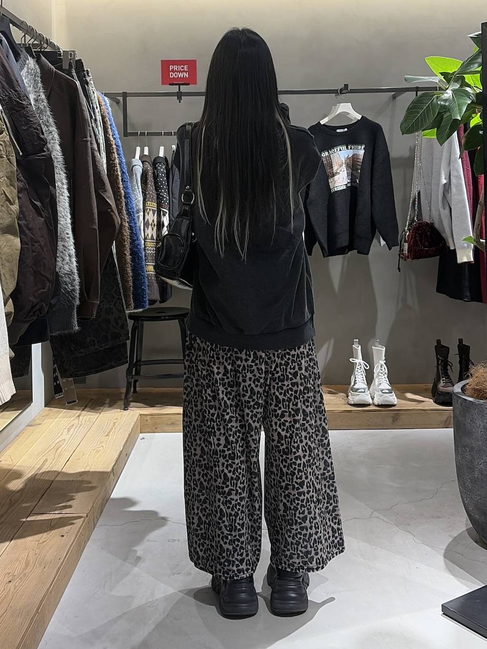 ブラック系のブーツ、グレー系のスウェット、ブラック系のショルダーバッグを着用したレディースの冬コーディネートの3枚目の写真