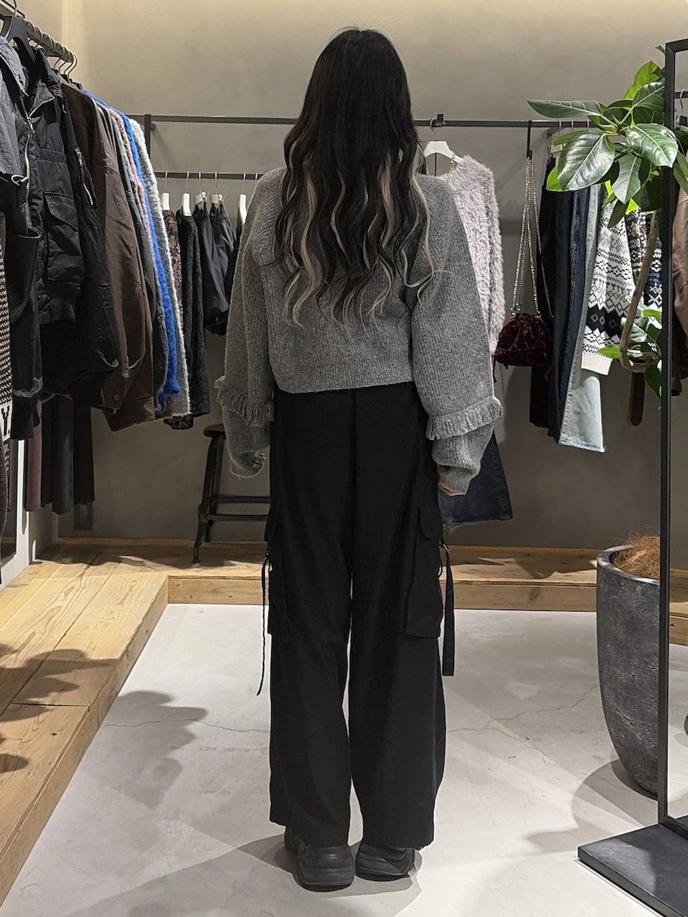 ブラック系のブーツ、ブラック系のスラックス、グレー系のTシャツ/カットソーを着用したレディースの冬コーディネートの3枚目の写真