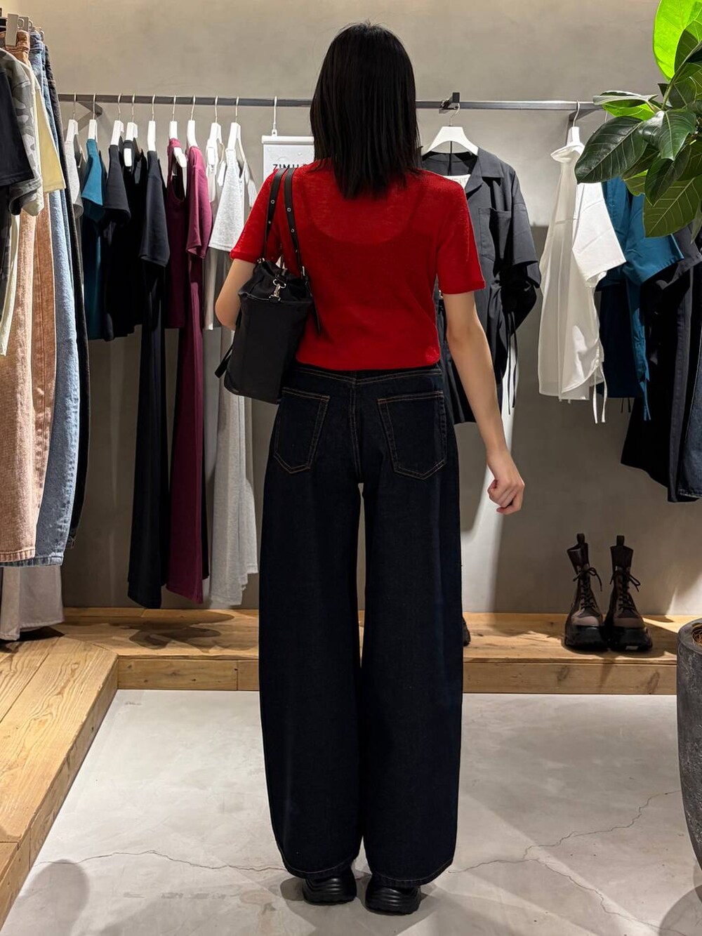 ブルー系のデニムパンツ、ブラック系のサンダル、ブラック系のトートバッグを着用したレディースの春コーディネートの3枚目の写真