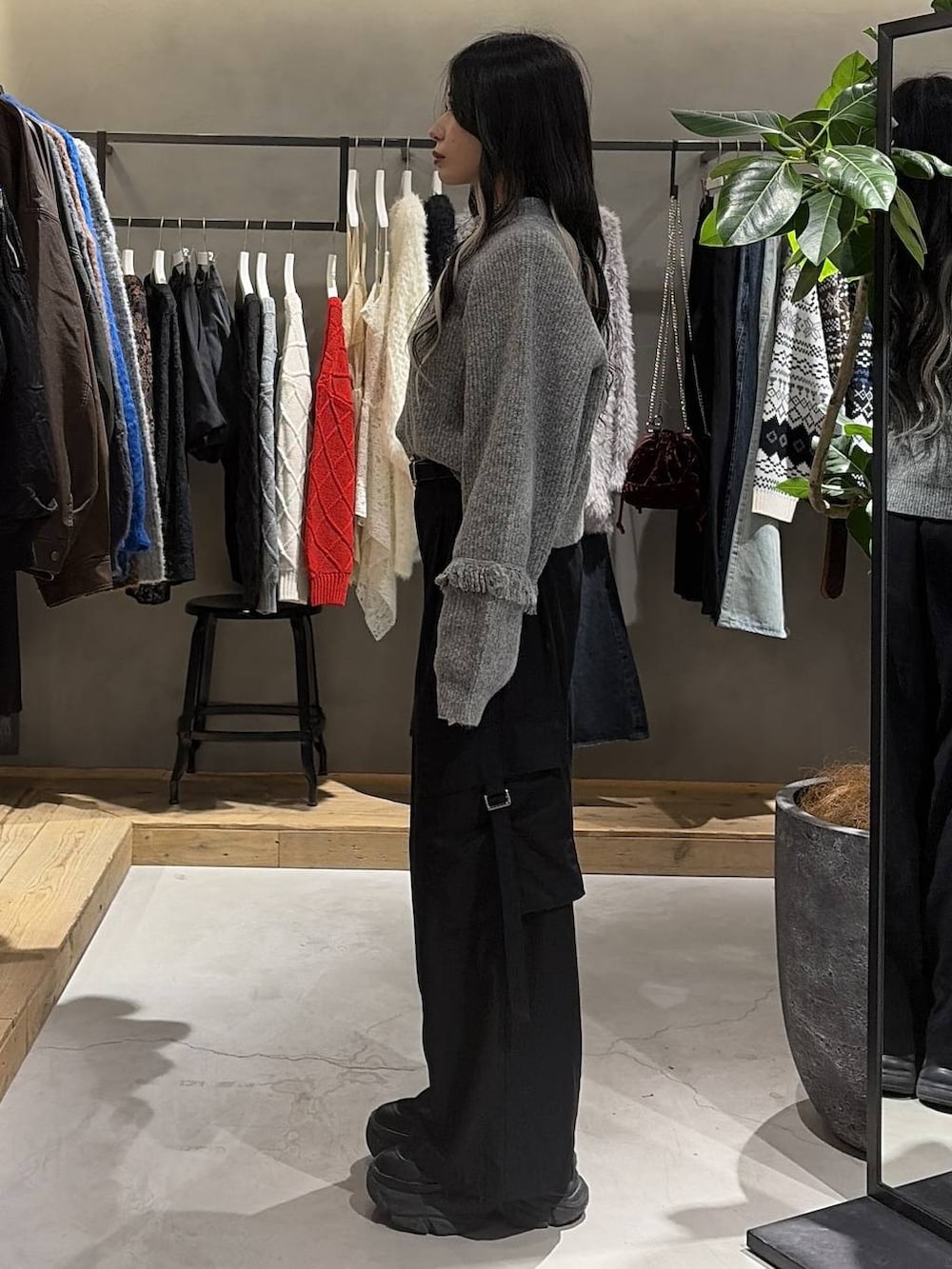 ブラック系のブーツ、ブラック系のスラックス、グレー系のTシャツ/カットソーを着用したレディースの冬コーディネートの2枚目の写真