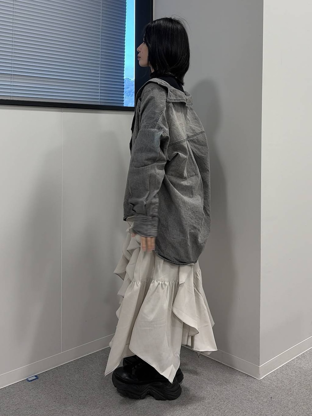 ブラック系のブーツ、ベージュ系のスカート、ブラック系のシャツ/ブラウスを着用したレディースの冬コーディネートの2枚目の写真