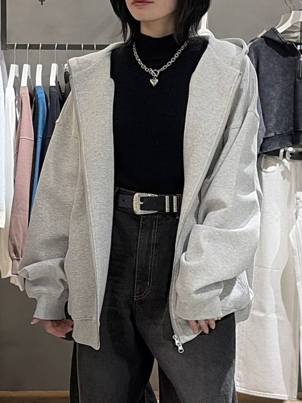 ブラック系のブーツ、グレー系のパーカー、ブラック系のデニムパンツを着用したレディースの冬コーディネートの4枚目の写真