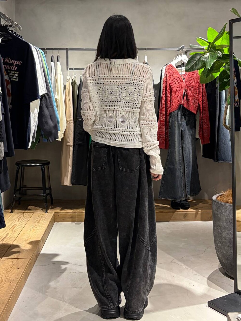 ブラック系のブーツ、ブラック系のデニムパンツ、ホワイト系のカーディガン/ボレロを着用したレディースの春コーディネートの3枚目の写真