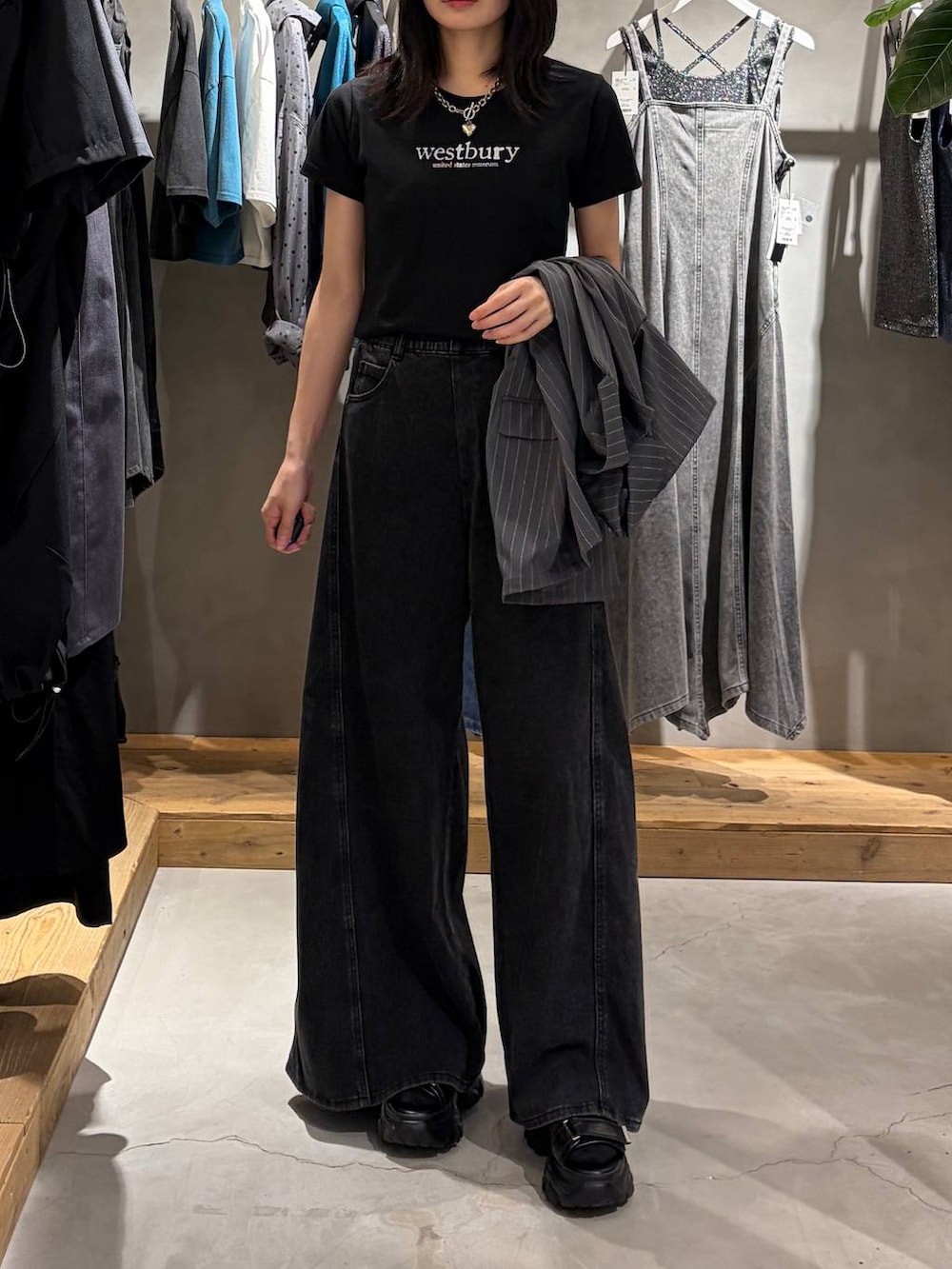 ブラック系のデニムパンツ、ブラック系のTシャツ/カットソー、ブラック系のサンダルを着用したレディースの夏コーディネートの6枚目の写真
