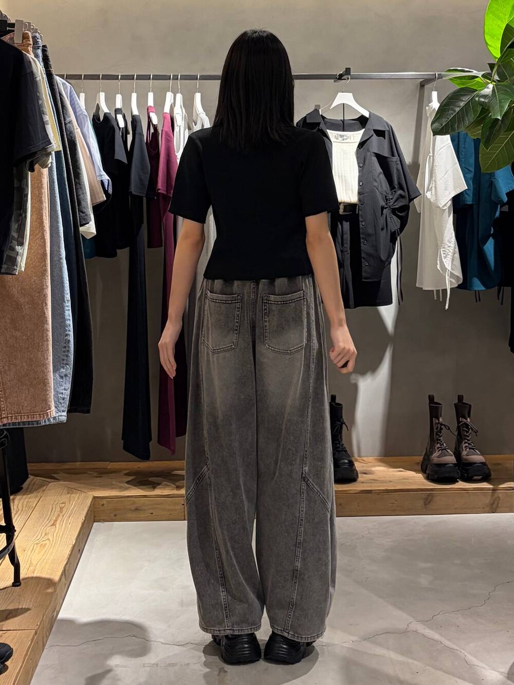 ブラック系のキャミソール、ブラック系のデニムパンツ、ブラック系のサンダルを着用したレディースの春コーディネートの3枚目の写真