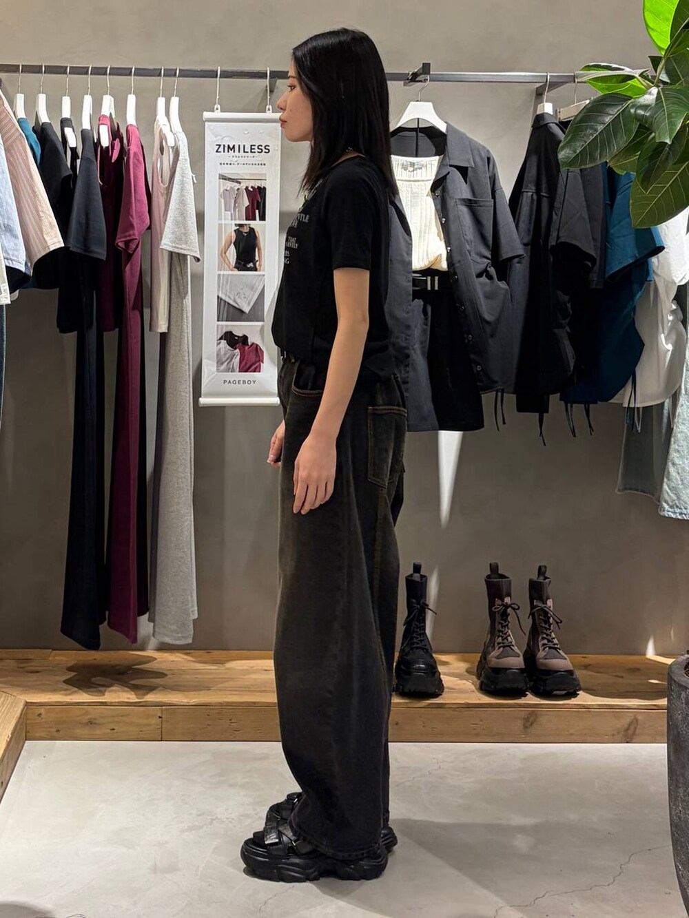 ブラック系のデニムパンツ、ブラック系のサンダル、ブラック系のTシャツ/カットソーを着用したレディースの夏コーディネートの2枚目の写真