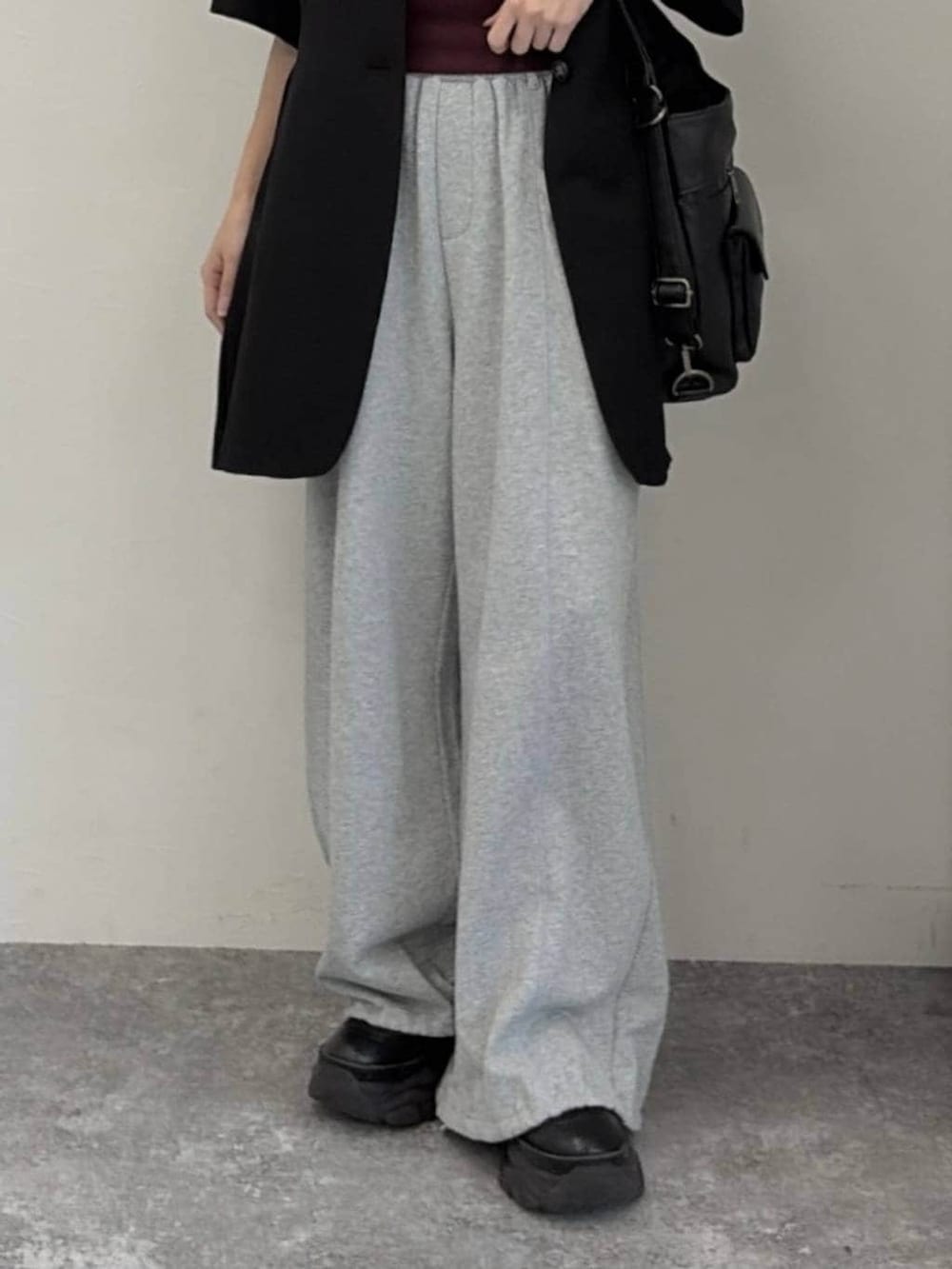 グレー系のスウェットパンツ、ブラック系のショルダーバッグ、ブラック系のテーラードジャケットを着用したレディースの春コーディネートの5枚目の写真