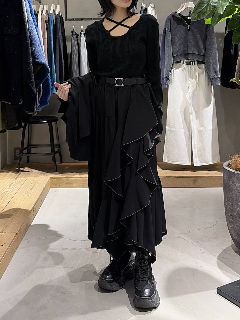 ブラック系のブーツ、ブラック系のスカート、ブラック系のボストンバッグを着用したレディースの冬コーディネートの6枚目の写真