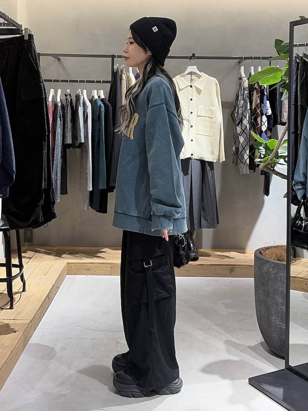 ブラック系のブーツ、ブラック系のスラックス、グリーン系のスウェットを着用したレディースの秋コーディネートの2枚目の写真