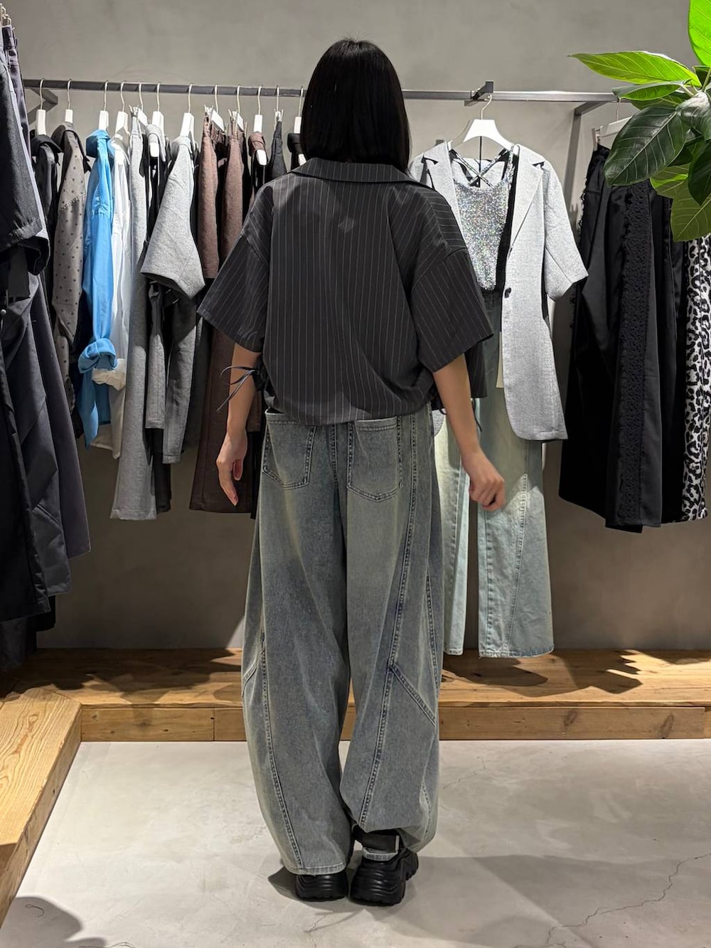 ブルー系のデニムパンツ、ブラック系のサンダル、ブラック系のタンクトップを着用したレディースの夏コーディネートの3枚目の写真