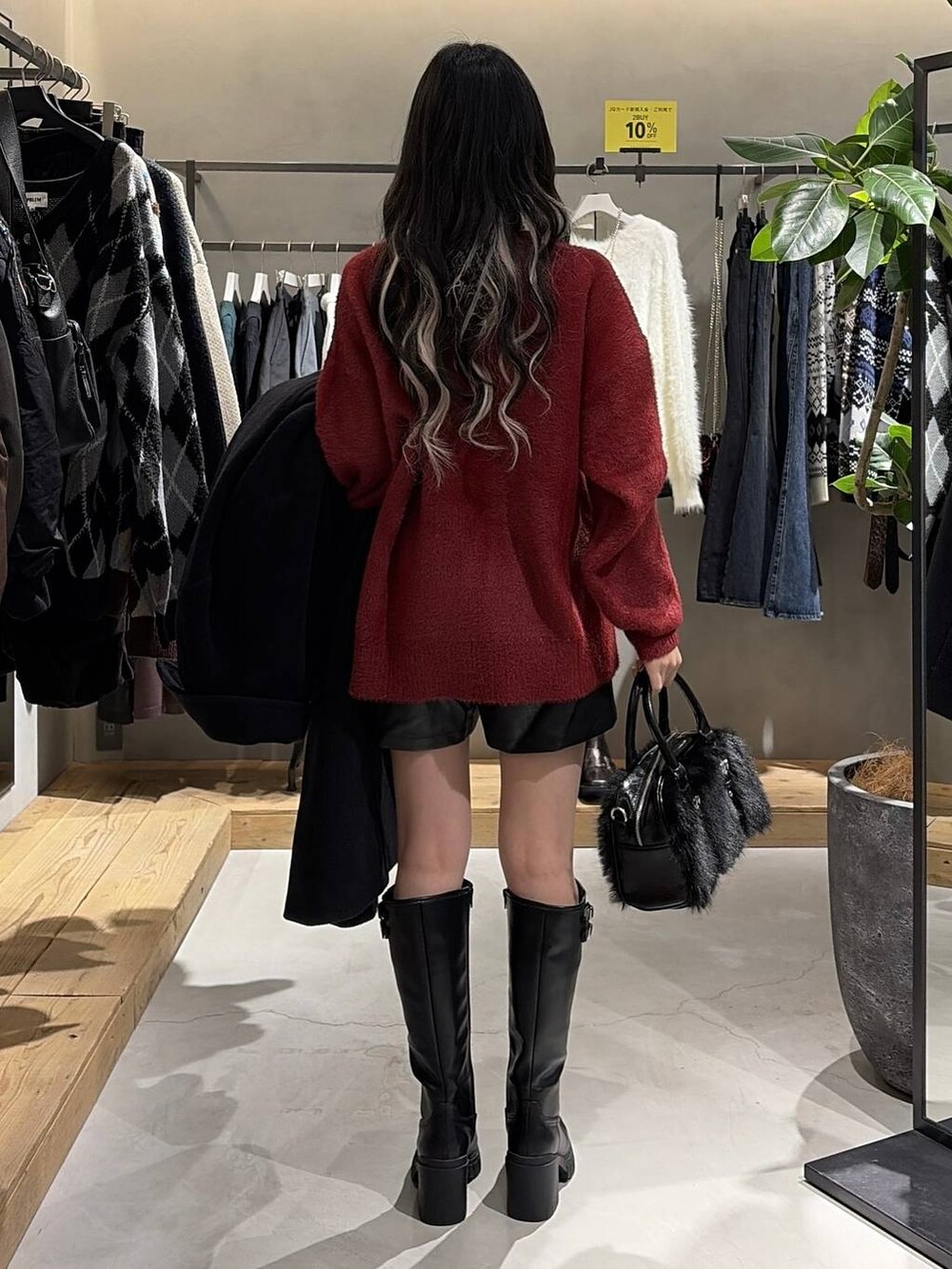 ブラック系のチェスターコート、ブラック系のブーツ、ブラック系のその他パンツを着用したレディースの秋コーディネートの3枚目の写真