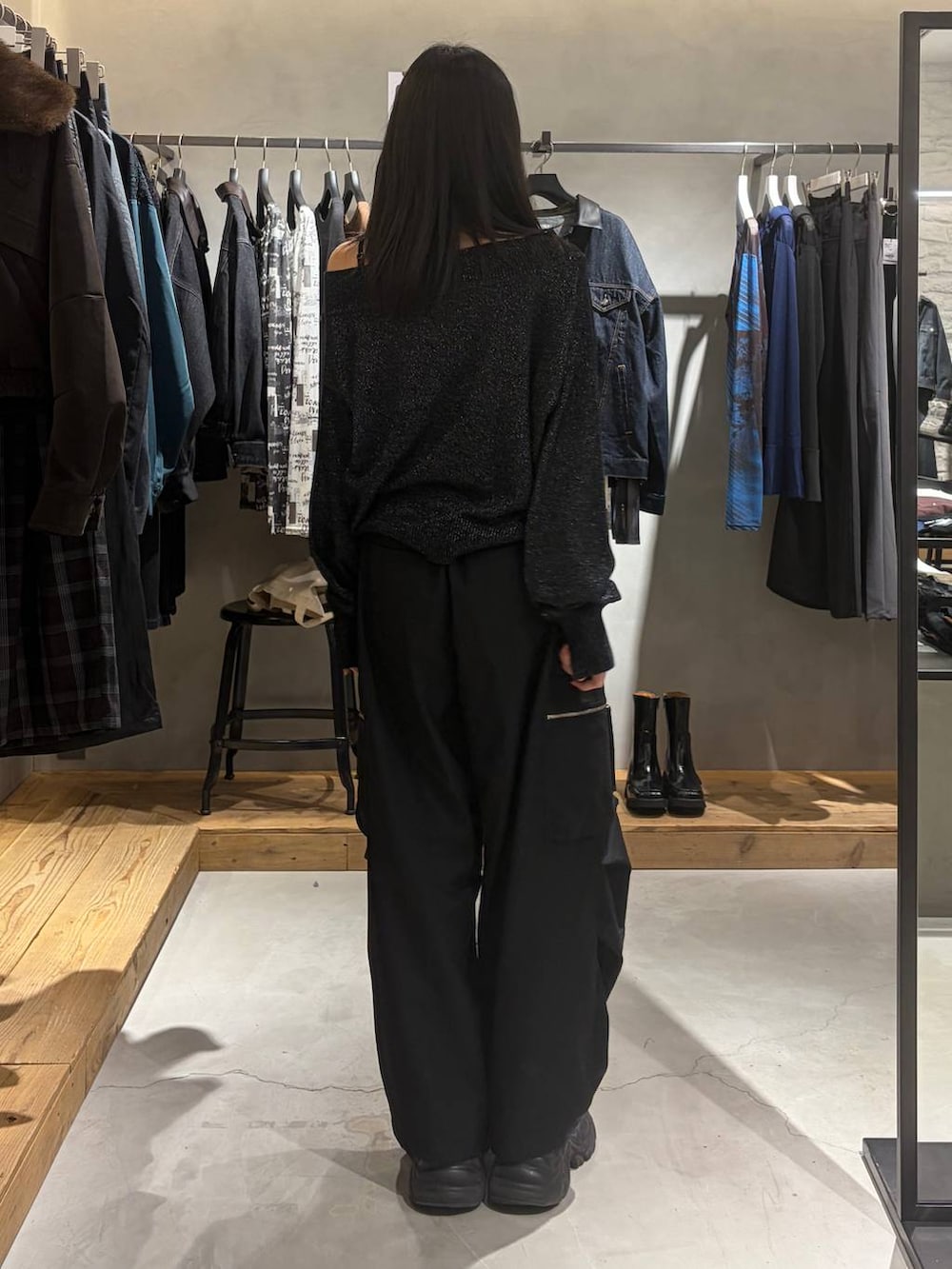 ブラック系のカーゴパンツ、ブラック系のニット/セーター、ブラック系のブーツを着用したレディースの秋コーディネートの3枚目の写真