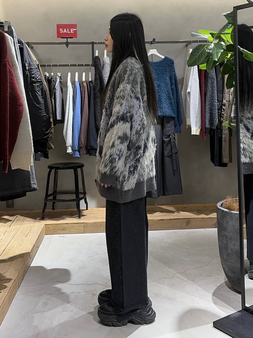 ブラック系のブーツ、グレー系のカーディガン/ボレロ、ブルー系のニット/セーターを着用したレディースの冬コーディネートの2枚目の写真