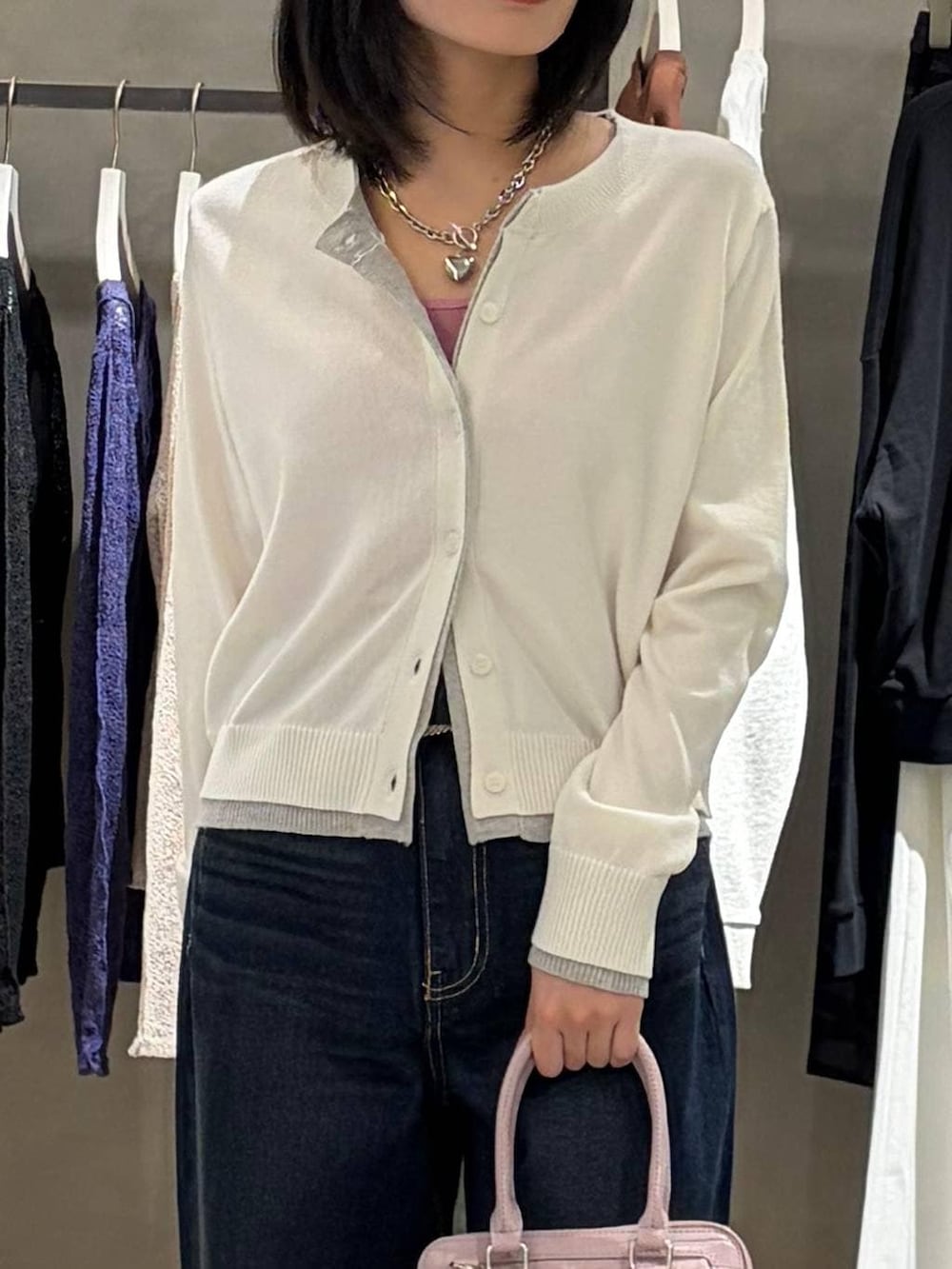 ブラック系のブーツ、ブルー系のスラックス、ピンク系のハンドバッグを着用したレディースの冬コーディネートの4枚目の写真