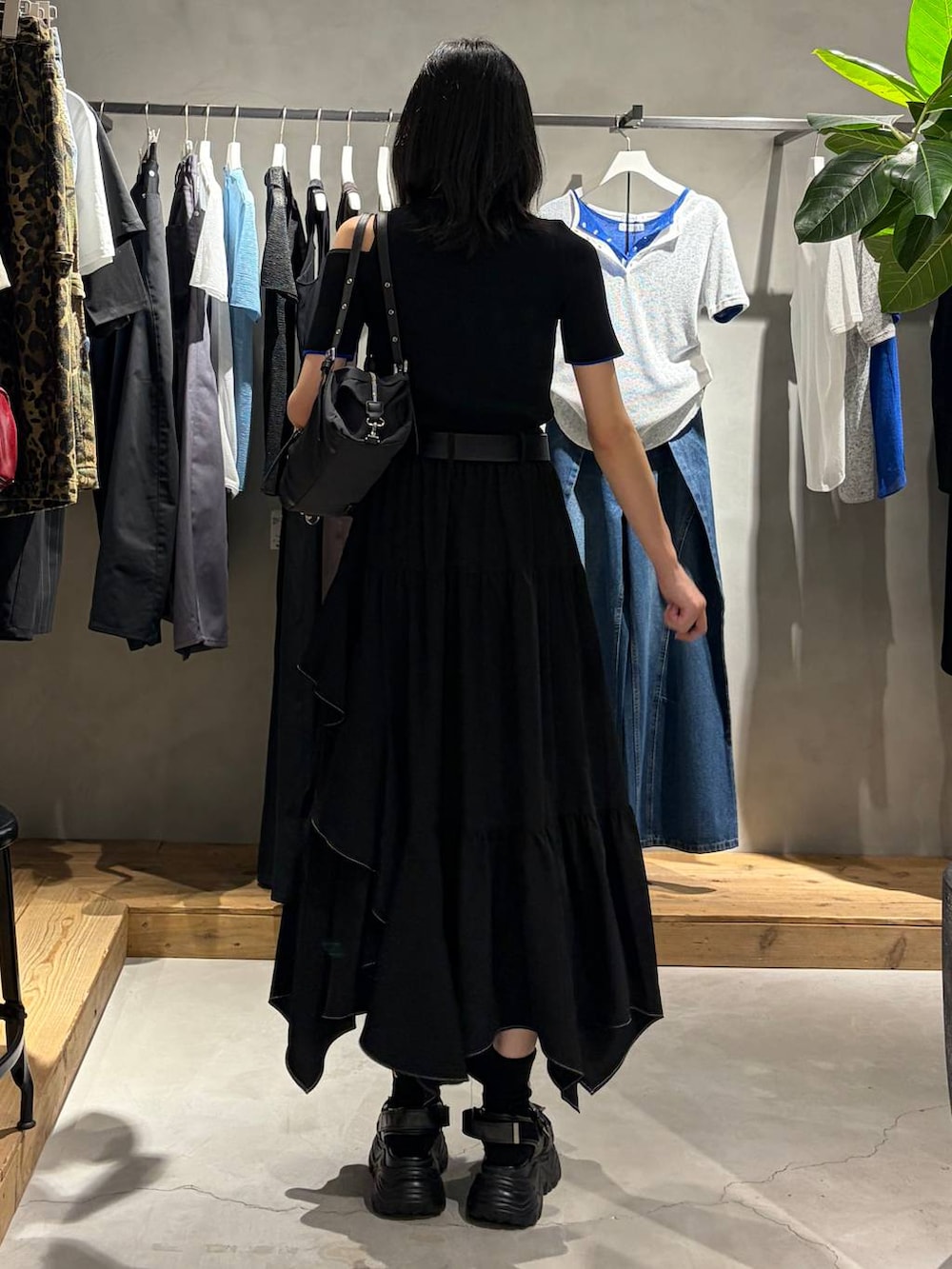 ブラック系のスカート、ブラック系のサンダル、ブラック系のトートバッグを着用したレディースの夏コーディネートの3枚目の写真