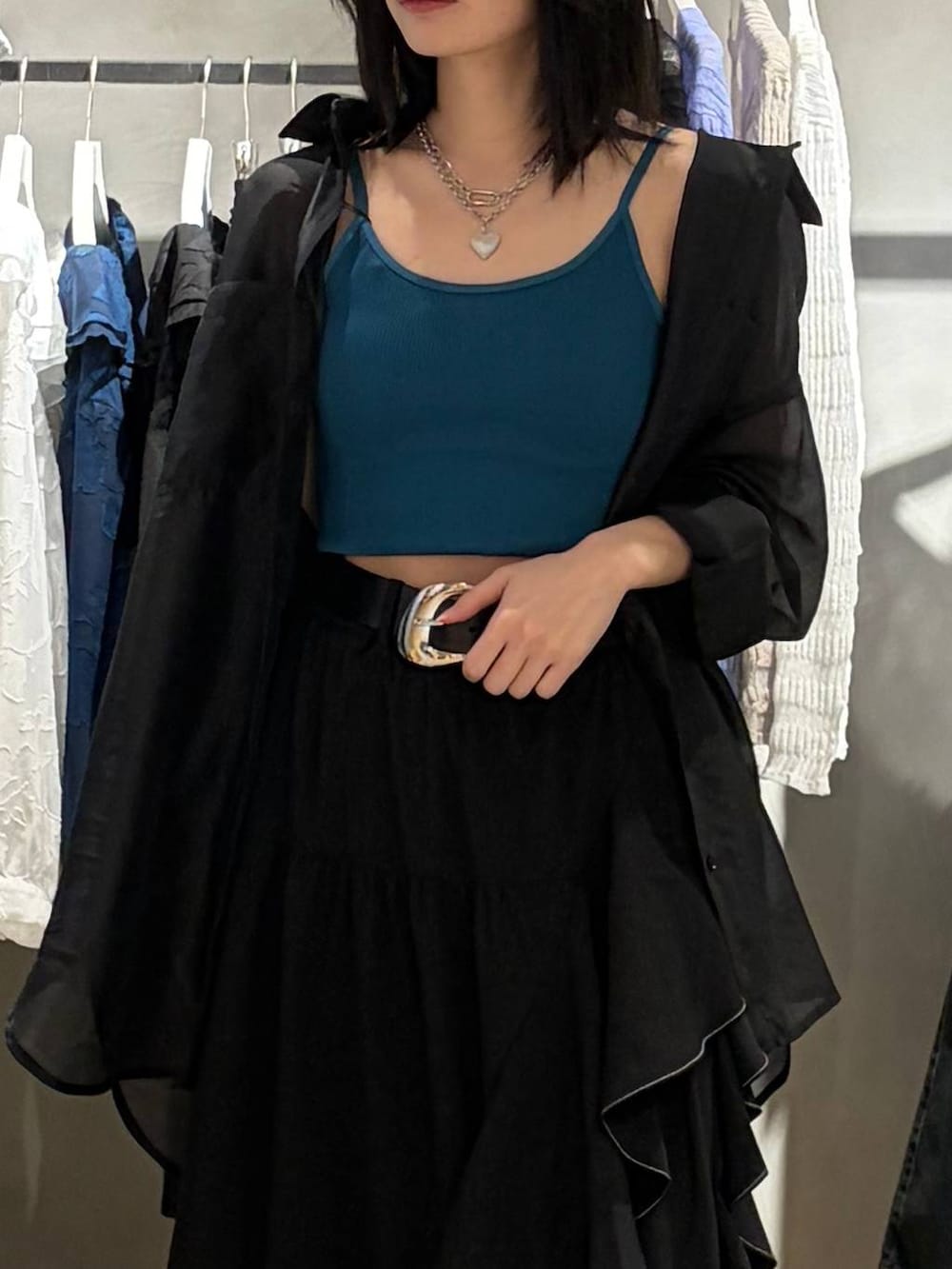 ブラック系のブーツ、グリーン系のキャミソール、ブラック系のスカートを着用したレディースの春コーディネートの4枚目の写真