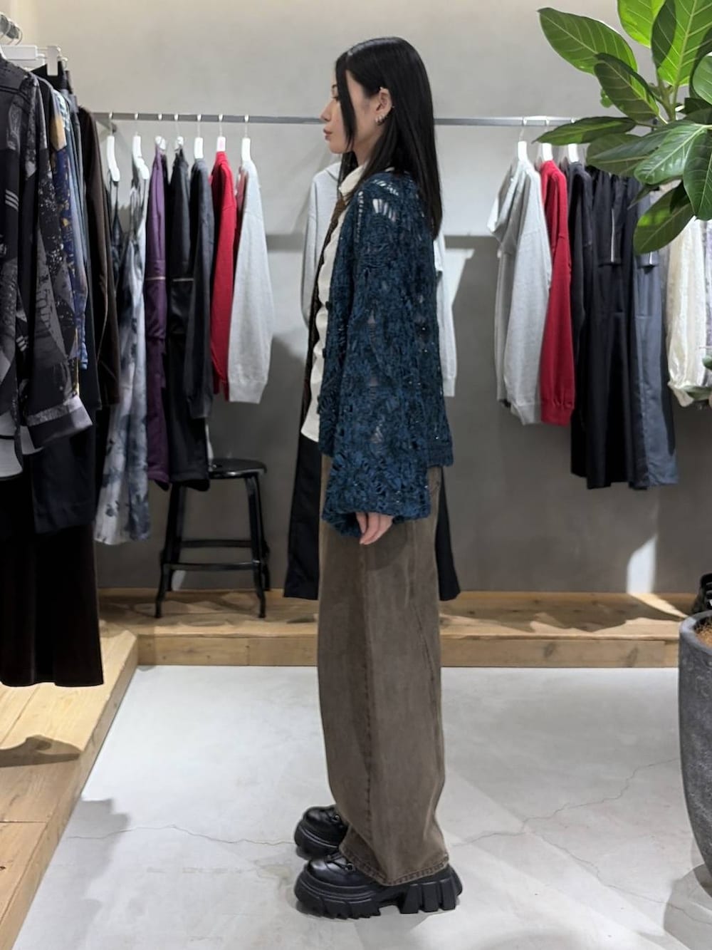 ブラック系のブーツ、ブラウン系のデニムパンツ、ブルー系のカーディガン/ボレロを着用したレディースの秋コーディネートの2枚目の写真