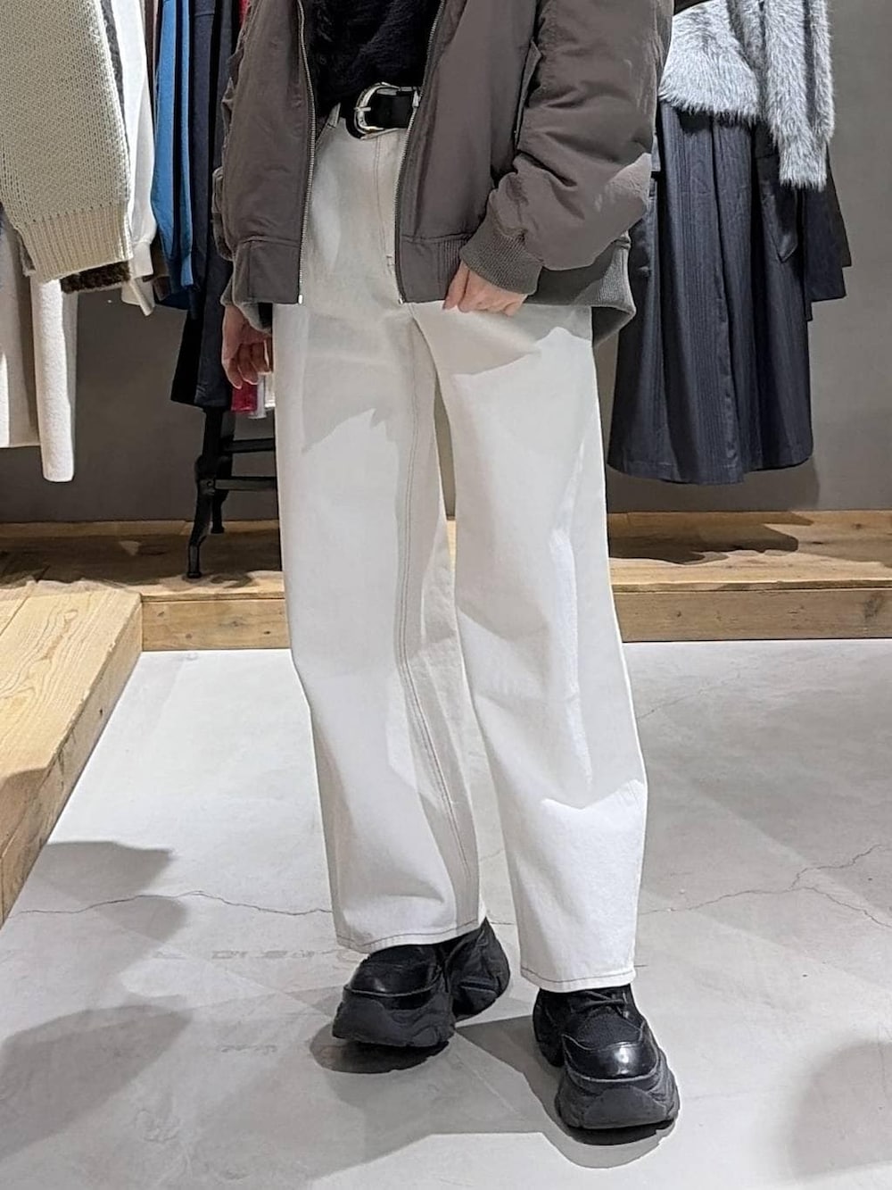 ブラウン系のブルゾン、ブラック系のニット/セーター、ホワイト系のスラックスを着用したレディースの冬コーディネートの5枚目の写真