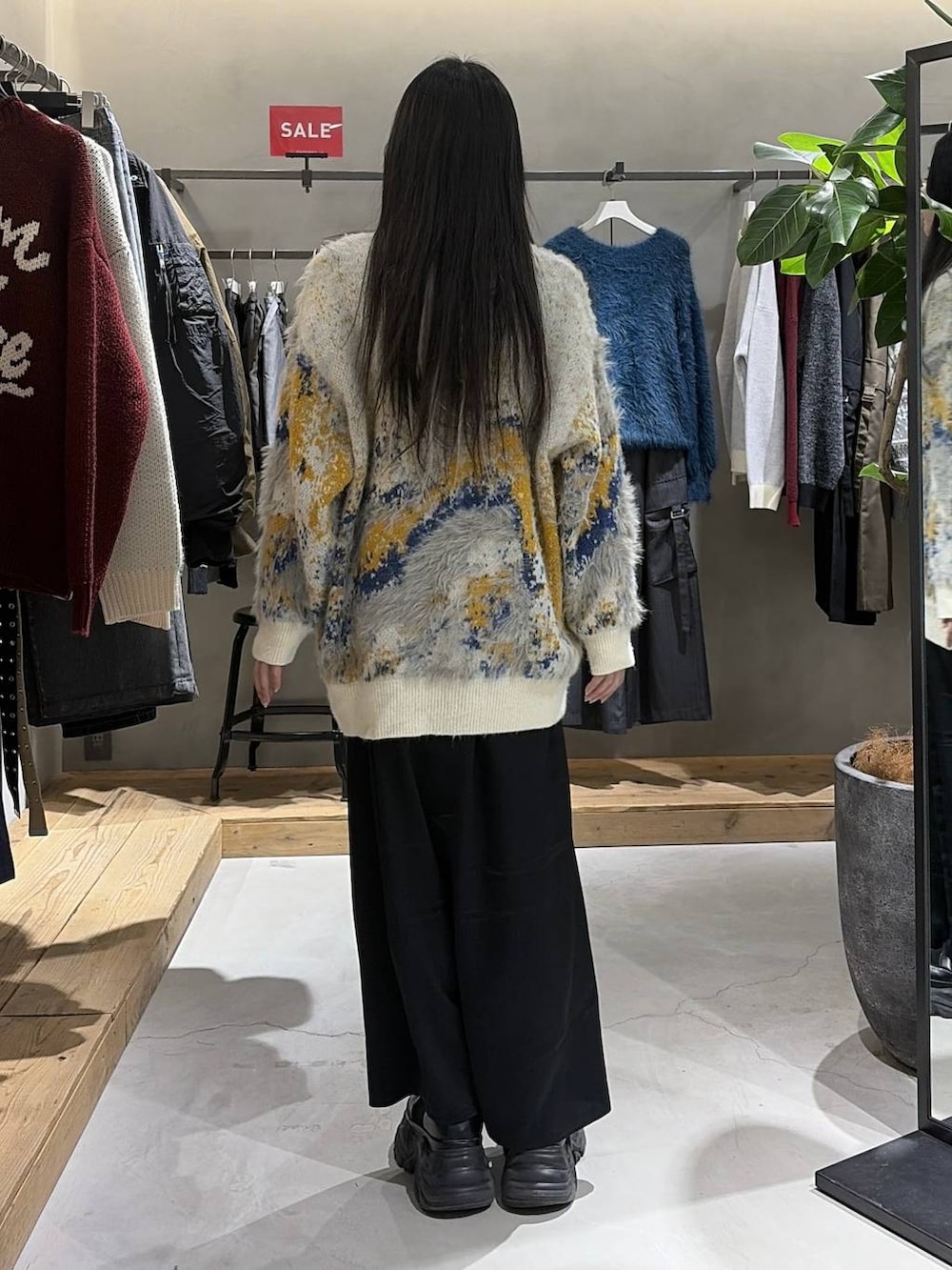 ホワイト系のカーディガン/ボレロ、ホワイト系のニット/セーター、ブラック系のスカートを着用したレディースの冬コーディネートの3枚目の写真