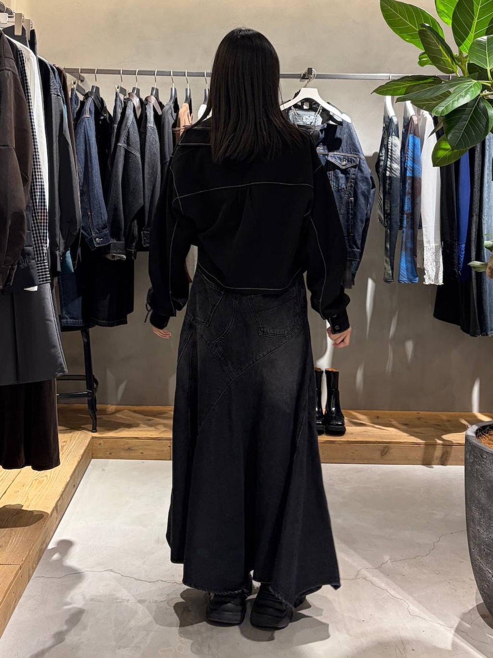 ブラック系のシャツ/ブラウス、ブラック系のデニムスカート、ブラック系のブーツを着用したレディースの秋コーディネートの3枚目の写真