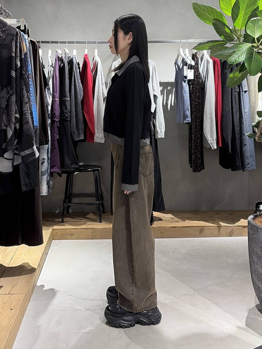 ブラウン系のデニムパンツ、ブラック系のスニーカー、ブラック系のカーディガン/ボレロを着用したレディースの秋コーディネートの2枚目の写真