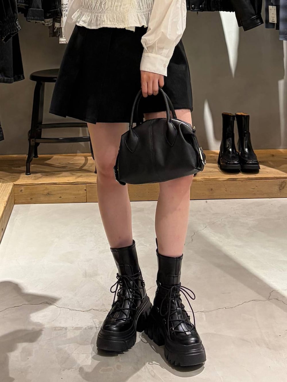 ブラック系のブーツ、ブラック系のその他パンツ、ホワイト系のTシャツ/カットソーを着用したレディースの秋コーディネートの5枚目の写真
