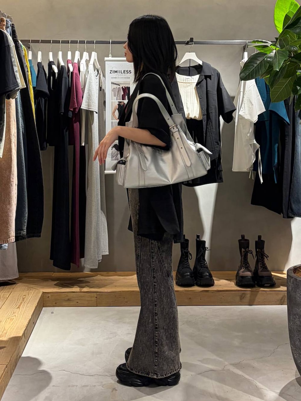 ブラック系のデニムパンツ、ブラック系のテーラードジャケット、シルバー系のハンドバッグを着用したレディースの春コーディネートの2枚目の写真