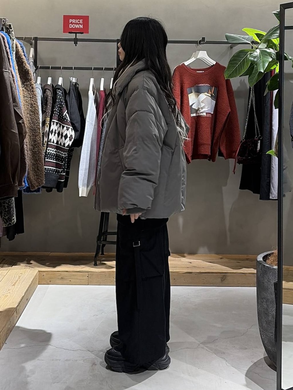 ブラック系のブーツ、グレー系のブルゾン、ブラック系のスラックスを着用したレディースの冬コーディネートの2枚目の写真