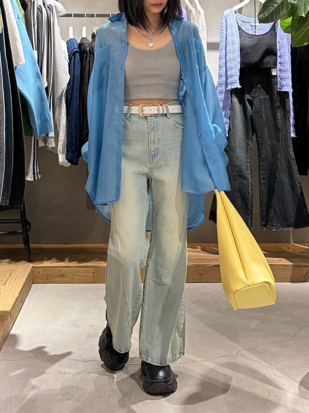 ブラック系のブーツ、グレー系のキャミソール、ブルー系のデニムパンツを着用したレディースの春コーディネートの6枚目の写真