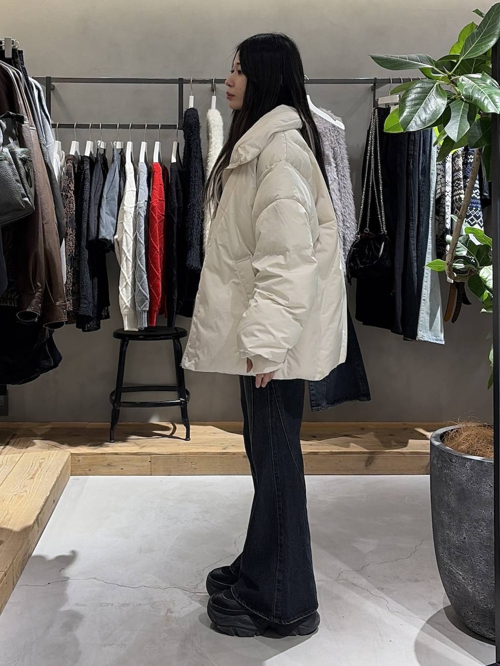 ブラック系のブーツ、ブルー系のデニムパンツ、ホワイト系のブルゾンを着用したレディースの冬コーディネートの2枚目の写真