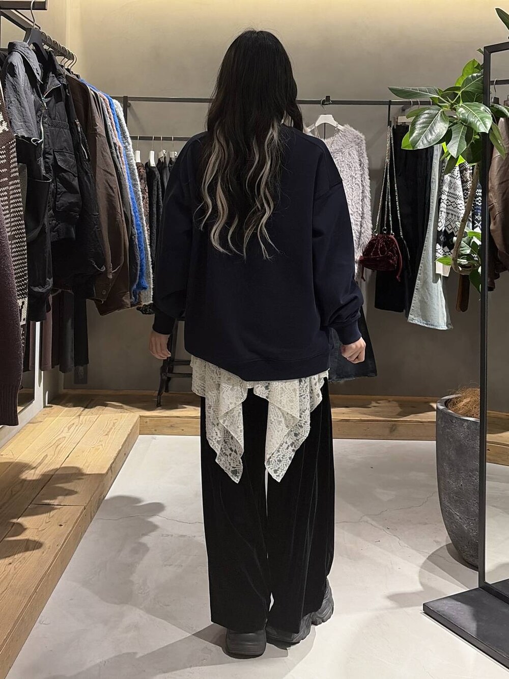 ブラック系のブーツ、ホワイト系のチュニック、ブラック系のその他パンツを着用したレディースの冬コーディネートの3枚目の写真