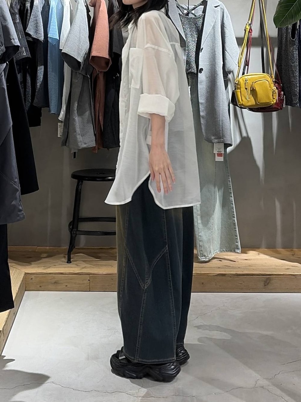 グリーン系のデニムパンツ、ブラック系のサンダル、ホワイト系のシャツ/ブラウスを着用したレディースの夏コーディネートの2枚目の写真