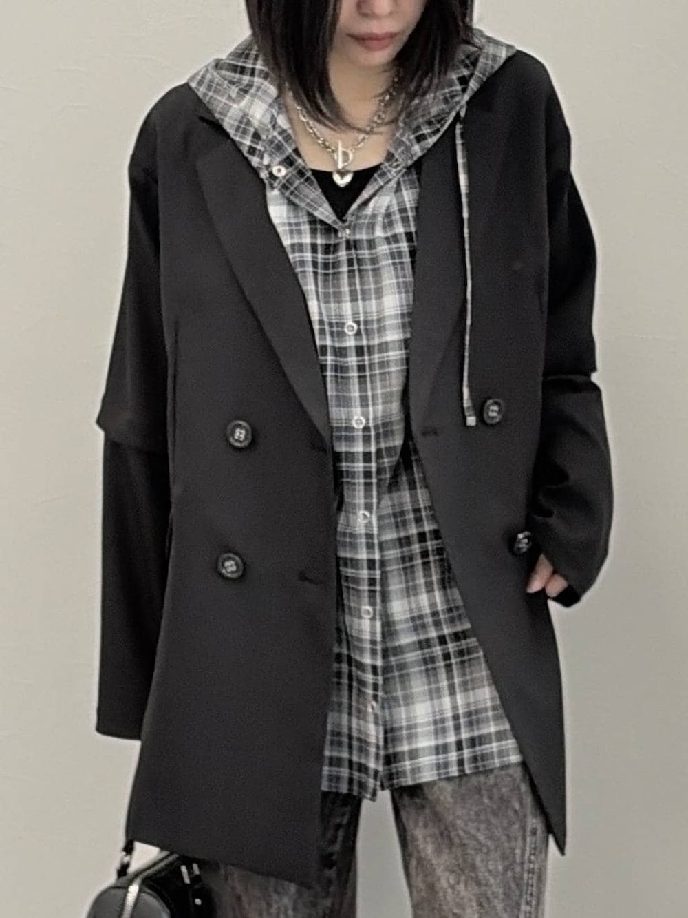 ブラック系のブーツ、ブラック系のボストンバッグ、ブラック系のテーラードジャケットを着用したレディースの春コーディネートの4枚目の写真